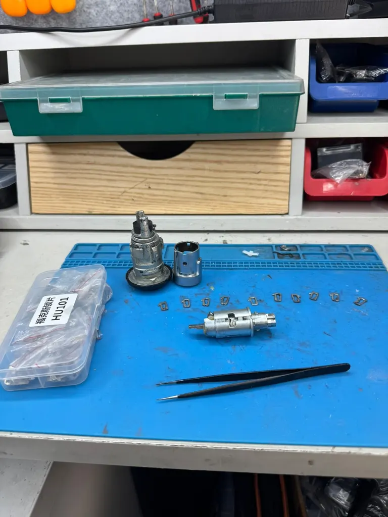 Ignition barrel stripped down on the workbench in the back of our van, with wafers and tweezers laid out