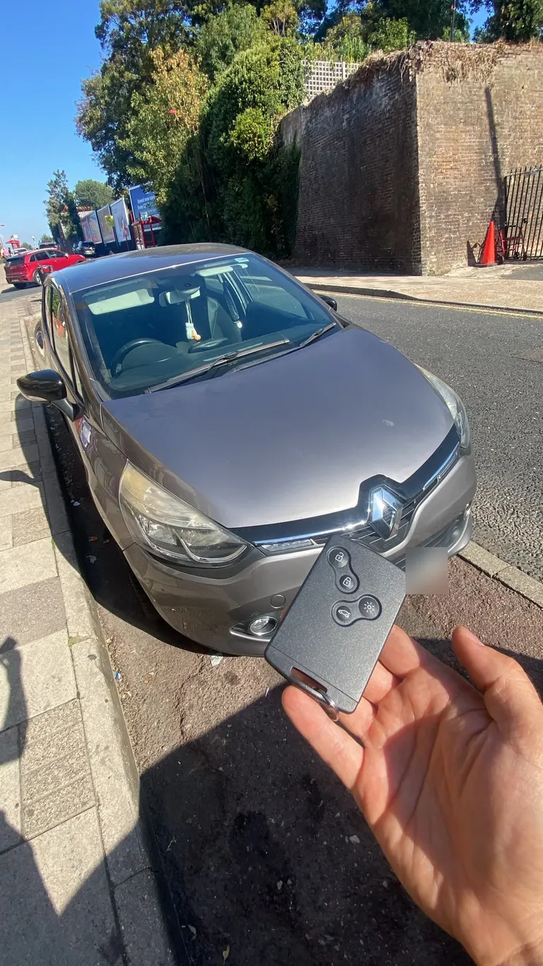 New Renault key card held in front of a grey Renault Clio in Rochester after an all-keys-lost job